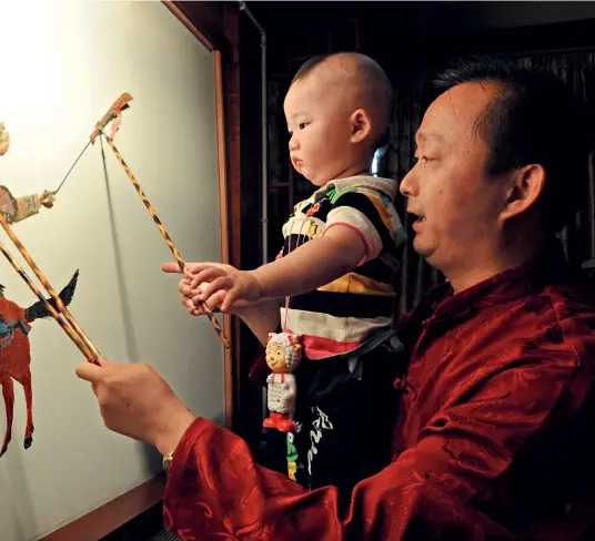  ?? Cnsphoto ?? 10 de junio de 2011. Un hombre y un niño experiment­an el juego de sombras en la ciudad antigua de Langzhong, provincia de Sichuan.