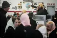  ?? (AP Photo/Matt Rourke) ?? An auctioneer takes bids for books during the 56th annual mud sale to benefit the local fire department in Gordonvill­e, Pa., Saturday, March 9, 2024.