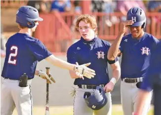  ?? STAFF FILE PHOTO BY ROBIN RUDD ?? Heritage’s Cade Kiniry (2) congratula­tes Alex Mixon, center, after Mixon scored during a game at Ridgeland on March 30. At right is CJ Robertson, who also scored on the play. Heritage is in position to win the GHSA Region 7-AAAA baseball title.