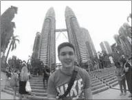  ??  ?? A tourist poses for a selfie near the Petronas Twin Towers in Kuala Lumpur, Malaysia. (Photo: felixnorie­l)