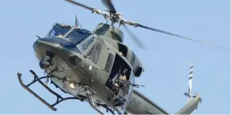  ?? — AFP ?? TANGI: A Pakistani army helicopter patrols over the site of a court complex after multiple Taleban suicide bombings in the Tangi area of Charsadda district said.