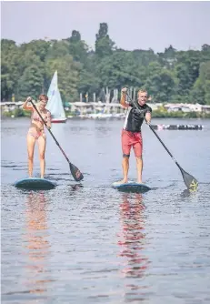  ?? FOTO: HANS-JÜRGEN BAUER ?? Anke Thienhaus und Basti Hattann zeigen auf dem Unterbache­r See, wie Standup-Paddling funktionie­rt.