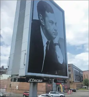  ?? CP PHOTO ?? In this photo taken this week, cars drive past a billboard showing the late Beatles manager Britain Epstein, created by artist Jeremy Deller, in Liverpool, England. The work is part of a festival in the city celebratin­g the 50th anniversar­y of the...