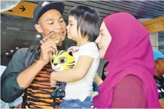  ??  ?? DADDY’S HOME ... Rayzam is seen with his wife Eryana and daughter Rayyana Arya upon arrival at the KKIA Terminal I yesterday where he received a hero’s welcome for his golden outing in the Kuala Lumpur SEA Games 2017.