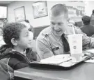  ?? DYLAN SLAGLE/BALTIMORE SUN MEDIA GROUP ?? Brian Cross, 7, eats breakfast with Westminste­r police recruit Joseph Tebo during the department’s Shop With a Cop event.