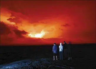  ?? MARCO GARCIA/ASSOCIATED PRESS ?? People watch the eruption of Mauna Loa on Monday, near Hilo, Hawaii. Mauna Loa, the world’s largest active volcano, erupted for the first time in 38 years.