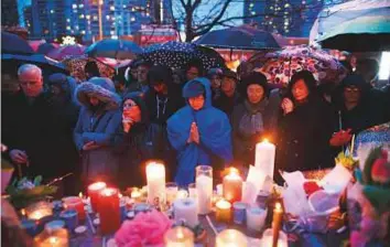  ?? AFP ?? ■ People pray for the victims of the mass killing at a vigil on Tuesday in Toronto. The number of women killed in the attack brings back memories of a 1989 massacre of 14 women.