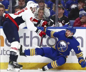  ?? Jeffrey T. Barnes/Associated Press ?? Washington’s Tom Wilson, left, checks Buffalo’s Connor Clifton in the second period Thursday night in Buffalo, N.Y.