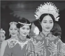  ?? LI FUHUA / FOR CHINA DAILY ?? Models showcase traditiona­l Chinese wedding dresses adorned with gold ornaments and crowns in Xiangyang, Hubei province.
