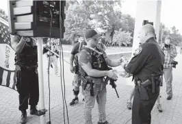  ?? KAITLIN MCKEOWN/STAFF ?? Newport News police Chief Steve Drew, right, exchanges chocolate milk for a soda with Kenneth“Mike”Dunn in front of the police headquarte­rs on Oct. 15.