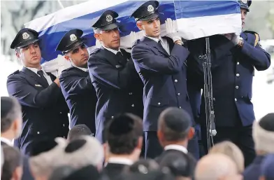  ?? ARIEL SCHALIT / THE ASSOCIATED PRESS ?? Knesset guards carry the flag-draped coffin of former Israeli president Shimon Peres during his funeral at the Mount Herzl National Cemetery in Jerusalem on Friday.