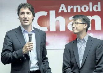  ?? CHRIS YOUNG/THE CANADIAN PRESS ?? Federal Liberal Leader Justin Trudeau speaks to supporters as he visits Liberal candidate for Scarboroug­h-Agincourt Arnold Chan, right, at his campaign office in Toronto in 2014. Chan has died of cancer.