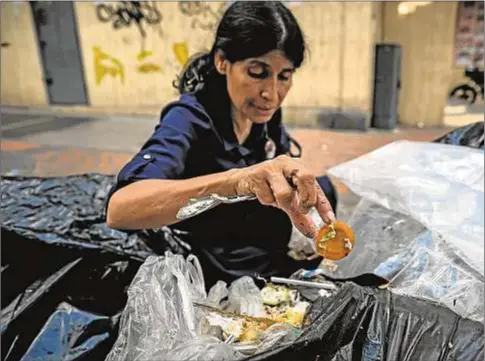  ?? EFE/Miguel Gutiérrez ?? Una mujer busca comida en la basura en Caracas (Venezuela)