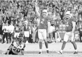  ?? CHRISTIAN PETERSEN/GETTY IMAGES ?? Holder Andy Lee (2) and kicker Phil Dawson watch his 57-yard winning field goal sail through the uprights.