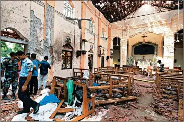  ?? GETTY ?? Sri Lankan officials inspect St. Sebastian’s Church in Negombo after it was attacked by a suicide bomber.