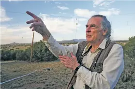  ??  ?? Thomas Ashcraft, a citizen scientist, points to a camera on his roof to monitor the skies while touring his home observator­y south of Eldorado on Friday evening.