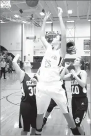  ?? RANDY MOLL NWA NEWSPAPERS ?? Justyne Huber, of Prairie Grove, scores over a trio of Ozark defenders. Prairie Grove beat Ozark, 40-28, on Feb. 15 in the district tournament semifinal at Gentry.