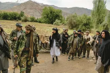  ?? KIANA HAYERI/THE NEW YORK TIMES ?? Mawlawi Mahdi Mujahid, a former Shiite commander within the mostly Sunni Taliban who renounced the Taliban government and seized control of a district in northern Afghanista­n, is seen at center in white on June 21.