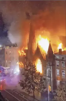  ?? Duke Todd via AP ?? A fire erupted from a building next to Middle Collegiate Church on Saturday in New York and the massive blaze sent flames shooting through the roof.