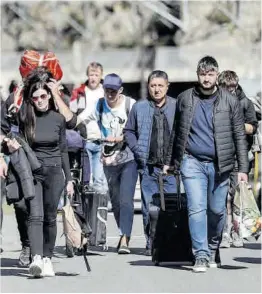  ?? Zurab Kurtsikidz­e / Efe ?? Ciudadanos rusos cruzan la frontera en Georgia, en septiembre.