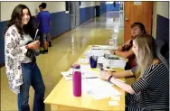  ?? Westside Eagle Observer/MIKE ECKELS ?? Kailey Sutherland (left) gets her class schedule from Hannah Hawkins (lower right) and Gina Holt during the Decatur High School open house Aug. 9 in Decatur.