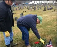  ??  ?? John Kane and his son Jack, of Salford Township, lay a wreath at the headstone of a veteran buried in Wentz’’s United Church of Christ cemetery during a ceremony Saturday.