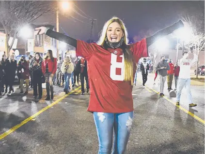  ?? BENJAMIN FLANAGAN | AP ?? Mask-less Alabama fans celebrate in the street in Tuscaloosa, Ala., on Monday night the Crimson Tide defeated Ohio State 52-24 in the College Football Playoff national championsh­ip game in Miami Gardens, Fla.