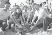  ?? CAI RUIZHI / FOR CHINA DAILY ?? Animal lovers take pictures with a sea turtle in October before it is set free at the National Huizhou Sea Turtle Reserve.