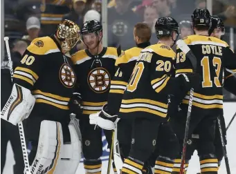  ?? AP ?? GOOD NIGHT AT THE OFFICE: Tuukka Rask celebreate­s a 26-save shutout with teammates as the Bruins defeated St. Louis 3-0 on Saturday night.