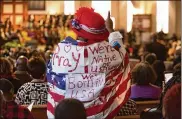  ?? PHIL SKINNER / AJC ?? A woman was draped in an American flag during the Martin Luther King Jr. Annual Ecumenical Commemorat­ive Service at Ebenezer Baptist Church located near The King Center in Atlanta on Monday.