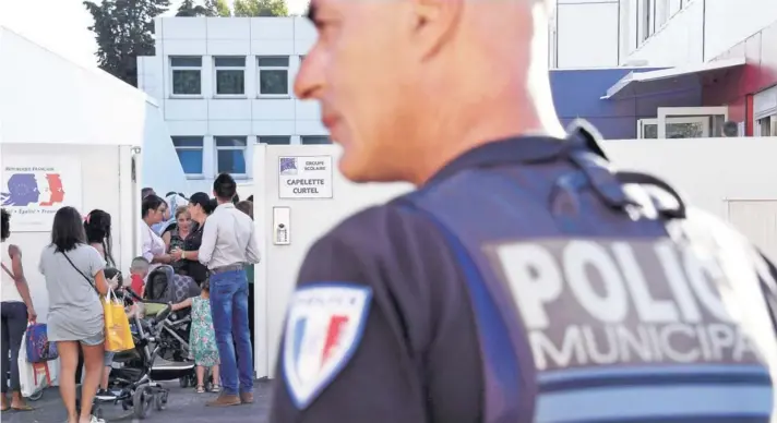  ??  ?? ► Un policía municipal hace guardia en la entrada de un colegio en Marsella, al inicio del año escolar el 1 de septiembre de 2016.