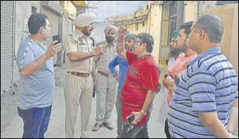  ?? GURPREET SINGH/HT ?? Police officials talking to shopkeeper­s after the robbery in Ludhiana on Friday.