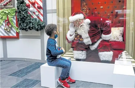  ?? The Patriot- News Dan Gleiter, The Patriot- News via AP ?? Kashden Dunlap, of Enola, Pa., visits with Santa Claus, with safety protocols in place, at Capital City Mall in Lower Allen Township, Pa., on Wednesday.