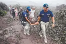  ?? Noe Perez, AFP/Getty Images ?? Police carry an injured man in Guatemala after the eruption Sunday of the Fuego Volcano.