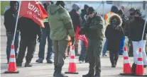  ?? PHOTOS: BRANDON HARDER ?? Security guards keep an eye at a blockade in front of a Saskenergy building manned by striking Unifor members.