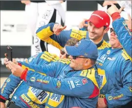  ?? Christina House Los Angeles Times ?? “WHAT IT means to win this race is hard to put into words,” says Alexander Rossi, who donned a red cap while taking photos with his jubilant team Sunday.