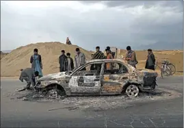  ?? RAHMAT GUL/AP ?? Afghans examine a burnt vehicle following an attack that claimed four U.S. lives in 2019 near the Bagram Air Base in Afghanista­n. The Taliban claimed responsibi­lity for the attack.