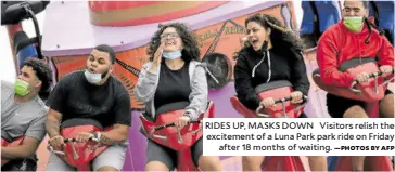  ?? —PHOTOS BY AFP ?? RIDES UP, MASKS DOWN Visitors relish the excitement of a Luna Park park ride on Friday after 18 months of waiting.