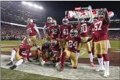  ?? TONY AVELAR — THE ASSOCIATED PRESS ?? San Francisco 49ers players celebrate after cornerback Richard Sherman, bottom center, intercepte­d a pass against the Green Bay Packers during the second half of the NFC Championsh­ip game Sunday in Santa Clara.