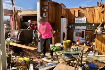  ?? AP Photo/Jay Reeves ?? Patti Herring sobs as she sorts through the remains of her home in Fultondale, Ala., on Tuesday after it was destroyed by a tornado.