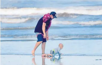  ?? JiM MicHAuD / BoSTon HeRALD ?? HITTING THE BEACH: A father with his infant son spend some time on the beach in Lynn on Sunday.