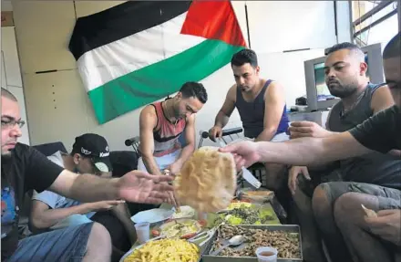  ??  ?? SEVERAL DOUBLE REFUGEES — those of Palestinia­n descent born in Syria — share a meal inside the squatters’ building where they live in Sao Paulo. Among them, brothers Rami and Mohammed Othman came from the Spina refugee camp in Damascus.