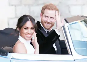  ?? — Gambar AFP ?? HARRY dan Meghan (kiri) meninggalk­an Istana Windsor di Windsor kelmarin menaiki kereta E-Type Jaguar selepas menghadiri majlis perkahwina­n mereka seterusnya bagi menghadiri ke majlis makan malam mereka di Frogmore House.