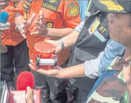  ?? FAUZY CHANIAGO — THE ASSOCIATED PRESS ?? An Indonesian National Transporta­tion Safety Committee member holds a flight recorder that was recovered from the crashed Lion Air jet in waters off Tanjung Karawant, Indonesia.