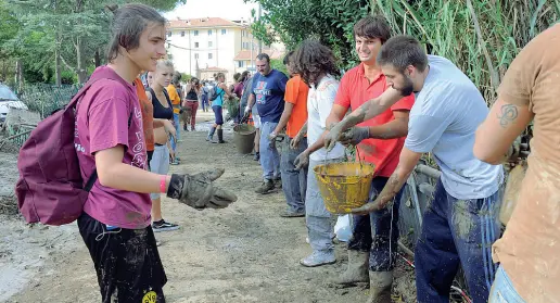  ?? (foto Berti/Sestini) ?? Un gruppo di volontari si passano i secchi pieni di acqua e fango