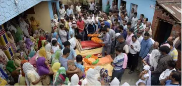  ??  ?? Villagers and relatives of school children killed in the bus crash prepare their bodies ahead of a cremation ceremony near Nurpur. — AFP photo