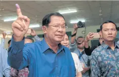  ?? AP ?? Hun Sen shows off his inked finger after voting yesterday.