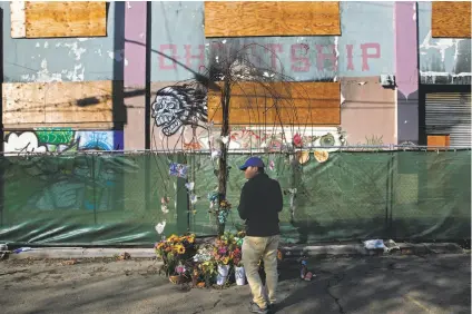  ?? Michael Macor / The Chronicle ?? David Nguyen pays his respects at a memorial to the victims of the Ghost Ship fire, which killed 36 on Dec. 2, 2016.