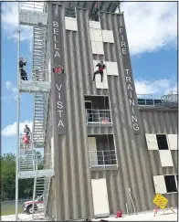  ?? (NWA Democrat-Gazette/Terri O’Byrne) ?? Firefighte­rs give a rappelling demonstrat­ion May 3 at the Bella Vista Fire Training Center.