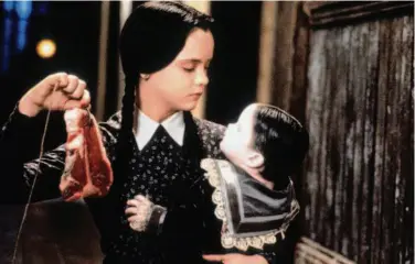  ?? Paramount 1993 ?? Wednesday Addams (Christina Ricci) holds baby Pubert Addams in “Addams Family Values,” screening Oct. 21 in McLaren Park as part of the Sundown Cinema series.